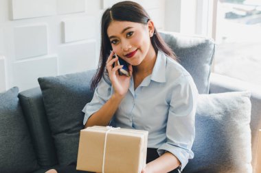 Asyalı kadın sme hakkında küçük bir iş kurdu. Kız siparişi internetten kabul ediyor. İnternet ve telefonla. KOBİ bağımsız bir iş kavramı.