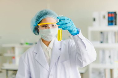 Asyalı bilim adamları laboratuvarda test ve analiz için kimyasallar hazırlıyorlar. Bilim adamları cam ve beyaz gömlekleri temizliyorlar. Bilim ve Kimya Konsepti