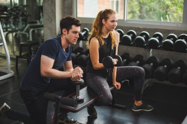 Spor eğitmeni genç bayan sporcuların eğitimini kontrol ediyor. Spor salonu konseptinde atlet fitness egzersizleri.