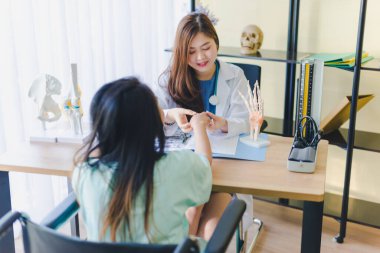 Doktor hastanın hastalığını ve bilek kemiğindeki ağrıyı tedavi etmek için durumunu inceliyor..