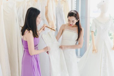 Gelin ve nedime, yaklaşan düğünü için dükkanda gelinlik seçiyorlar. Sevgililer Günü Aşk Kavramı.