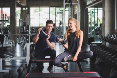 Spor eğitmeni genç bayan sporcuların eğitimini kontrol ediyor. Spor salonu konseptinde atlet fitness egzersizleri.