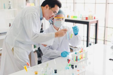 Asyalı bilim adamları, erkekler ve kadınlar birçok bilimsel ekipmana sahip laboratuvarlarda çeşitli renk kimyasallarının test ve analizine yardım ediyorlar..