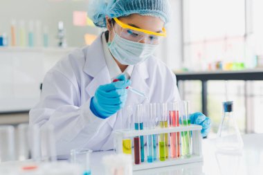 Asyalı bilim adamları laboratuvarda birçok kimyasalı test edip analiz ediyorlar. Bilim ve Kimyasal Konseptler.