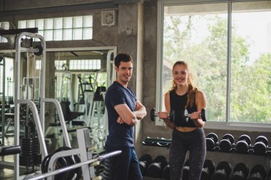 Spor eğitmeni genç bayan sporcuların eğitimini kontrol ediyor. Spor salonu konseptinde atlet fitness egzersizleri.