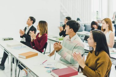 Asyalılar seminerlere katılır ve eğitim odasındaki hoparlörlerden ders dinlerler. Bazı insanlar not alır. Bazı insanlar anlatıcı sormak için ellerini kaldırdı. Ve konuşmacı konuşmasını bitirdiğinde alkışlandı..