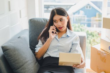 Asyalı kadın sme hakkında küçük bir iş kurdu. Kız siparişi internetten kabul ediyor. İnternet ve telefonla. KOBİ bağımsız bir iş kavramı.