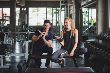 Spor eğitmeni genç bayan sporcuların eğitimini kontrol ediyor. Spor salonu konseptinde atlet fitness egzersizleri.