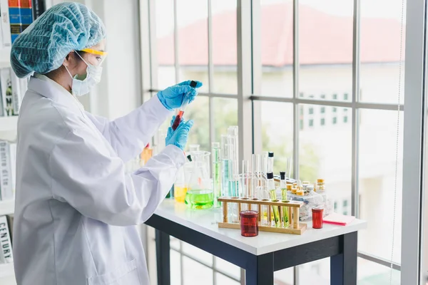 Asian scientists are preparing chemicals for testing and analysis in the laboratory. Scientists clear glasses and white shirts. Science and Chemistry Concept