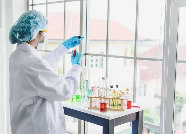 Asian scientists are preparing chemicals for testing and analysis in the laboratory. Scientists clear glasses and white shirts. Science and Chemistry Concept