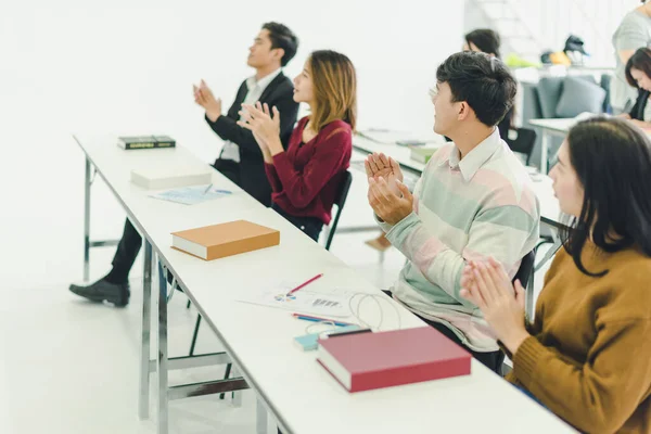 Asyalılar seminerlere katılır ve eğitim odasındaki hoparlörlerden ders dinlerler. Bazı insanlar not alır. Bazı insanlar anlatıcı sormak için ellerini kaldırdı. Ve konuşmacı konuşmasını bitirdiğinde alkışlandı..