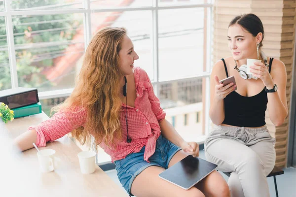 2人の美しい若い女性がコーヒーを飲んで電話をしている リラクゼーションという概念は — ストック写真