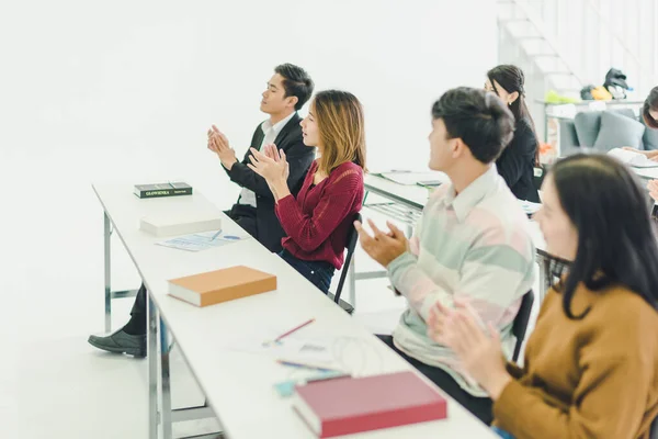 Asians attend seminars and listen to lectures from speakers in the training room. Some people take notes. Some people raised their hands to ask the narrator. And applauded when the speaker finished speaking.