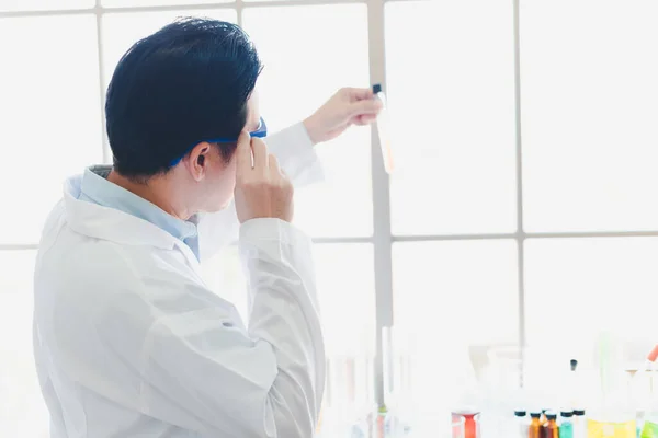 Asian scientists are preparing chemicals for testing and analysis in the laboratory. Scientists clear glasses and white shirts. Science and Chemistry Concept