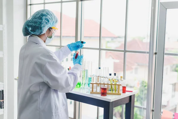 Asian scientists are preparing chemicals for testing and analysis in the laboratory. Scientists clear glasses and white shirts. Science and Chemistry Concept