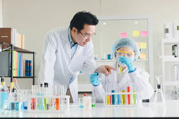 在拥有许多科学仪器的实验室里 亚洲科学家 男性和女性正在帮助测试和分析各种颜色的化学品 — 图库照片