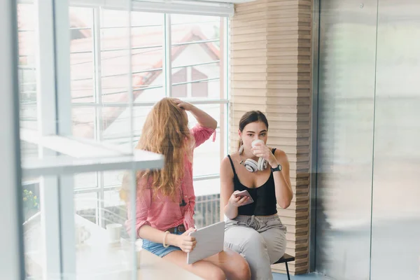 Две Красивые Девушки Пьют Кофе Играют Телефон Концепция Расслабления — стоковое фото