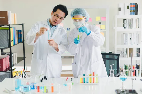 Asian Scientists Men Women Helping Test Analyze Various Color Chemicals Stock Image