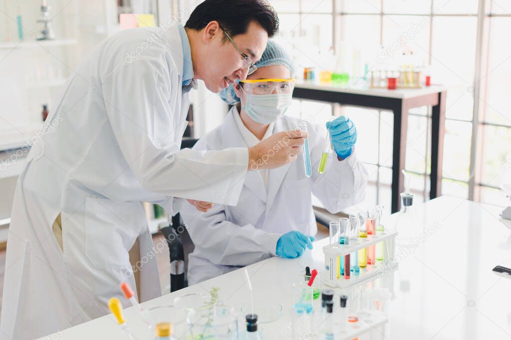 Asian scientists, men and women are helping to test and analyze various color chemicals in laboratories that have many scientific equipment.