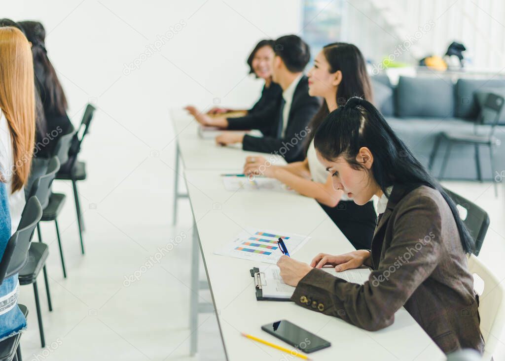 Asians attend seminars and listen to lectures from speakers in the training room. Some people take notes. Some people raised their hands to ask the narrator. And applauded when the speaker finished speaking.