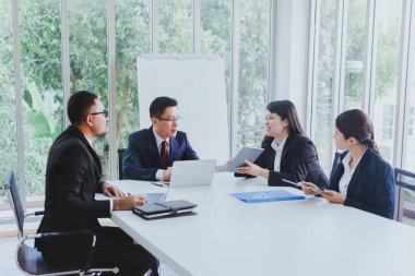 İstatistiksel grafik olarak sunum için Asyalı şirket toplantıları. İş adamlarından oluşan ekip, iş yerinin toplantı odasında yapılan pazarlama çalışmaları hakkında danıştı..