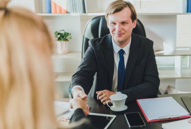İş adamları iş görüşmelerini başarıyla yapabildiklerinde genç müşterilerle tokalaşıyorlar..