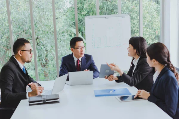 Asian company meetings for presentation as statistical graphs. The team of businessmen consulted about the marketing work in the meeting room of the workplace.