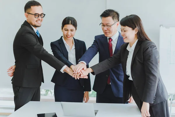 Asian company meetings for presentation as statistical graphs. Team of business people shaking hands after a business deal with success.