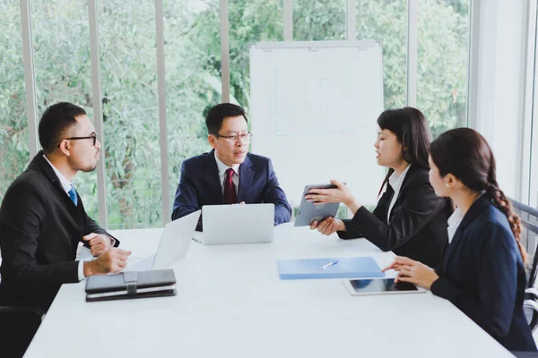 Asian company meetings for presentation as statistical graphs. The team of businessmen consulted about the marketing work in the meeting room of the workplace.