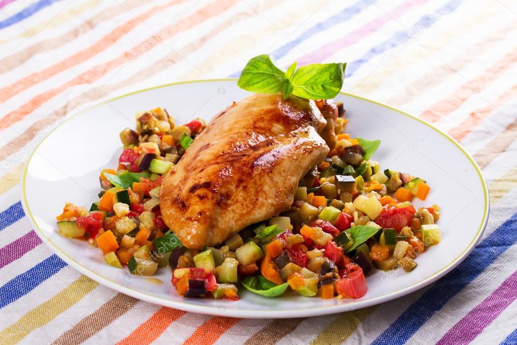 Fried chicken breast with sauteed vegetables: eggplant, carrot, zucchini, squash and tomatoes