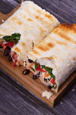 Tavuk, siyah fasulye, ıspanak ve domates burrito