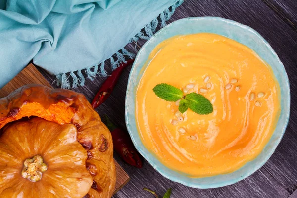 Bowl of pumpkin soup and  whole pumpkin. Butternut squash cream soup