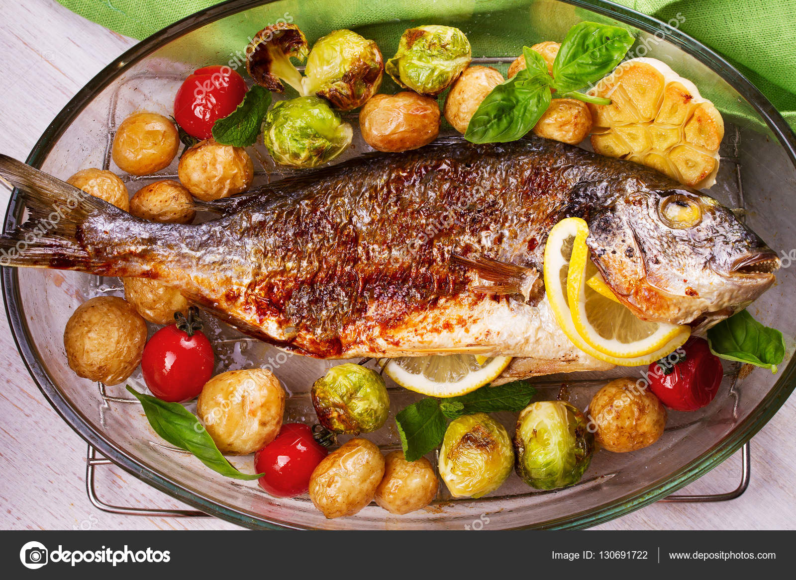 Roasted dorado fish with brussels sprouts, tomatoes, garlic, young potato and greens — Stock