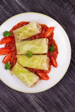 Lahana domates soslu et, pilav ve sebze ile alır. Etli lahana dolması yaprakları