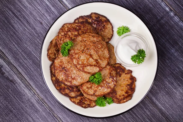 Wątroby kotleciki z kwaśną śmietaną i pietruszka. Fritters wątroby lub wątroby ciasta — Zdjęcie stockowe