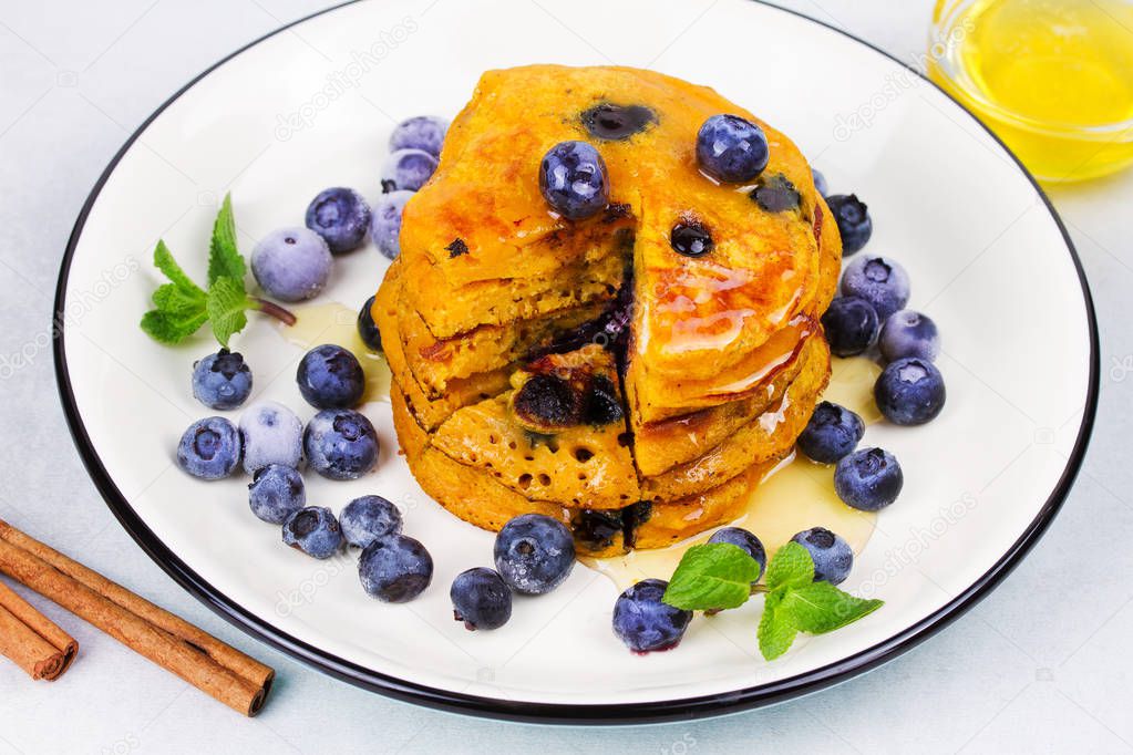 Pumpkin pancakes with blueberries, honey and cinnamon