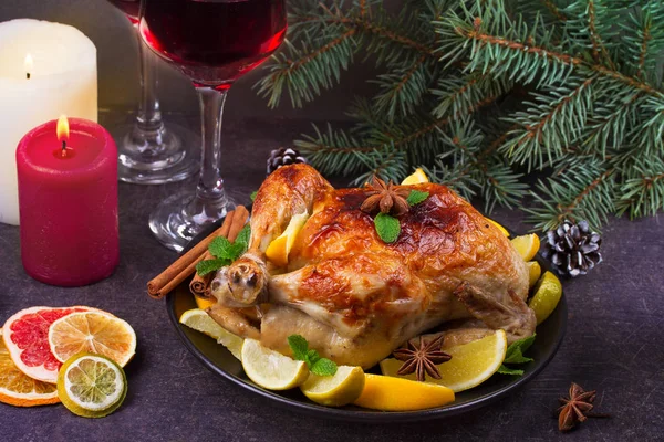 Праздничная рождественская индейка с апельсином, лимоном и лаймом. Бокалы красного вина и свечи — стоковое фото