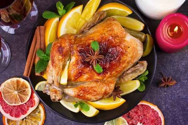 Neşeli Noel hindisi portakal, limon ve kireç ile pişmiş. Bardak kırmızı şarap ve mumlar