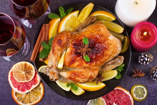 Neşeli Noel hindisi portakal, limon ve kireç ile pişmiş. Bardak kırmızı şarap ve mumlar
