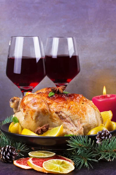 Festive Christmas turkey baked with orange, lemon and lime. Glasses of red wine and candles — Stock Photo, Image