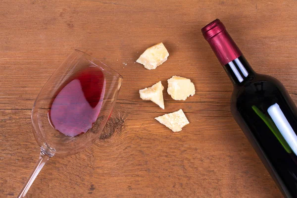 Glass and bottle of red wine with parmesan. Wine and cheese still life. View from above, top studio shot — Stock Photo, Image