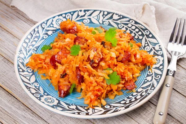 Stewed cabbage with sausages, carrot, onion and tomatoes — Stock Photo, Image