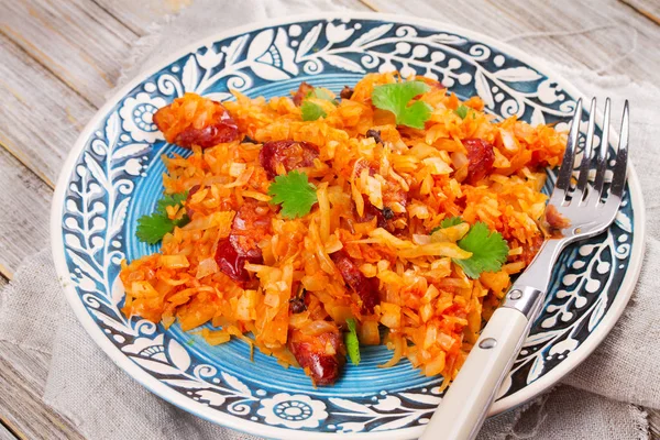 Stewed cabbage with sausages, carrot, onion and tomatoes — Stock Photo, Image