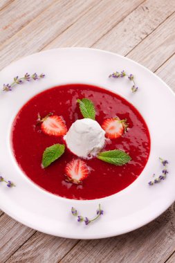 Dondurma ve nane ile çilek çorbası. Püresi çilek vanilyalı dondurma ile tepesinde nane yaprakları ile süslenmiş. Karışık çilek. Berry tatlı