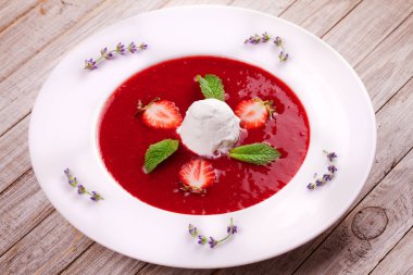 Dondurma ve nane ile çilek çorbası. Püresi çilek vanilyalı dondurma ile tepesinde nane yaprakları ile süslenmiş. Karışık çilek. Berry tatlı