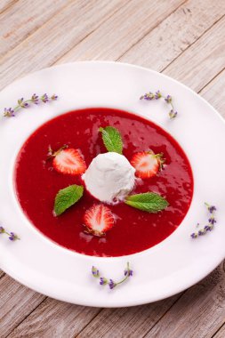 Dondurma ve nane ile çilek çorbası. Püresi çilek vanilyalı dondurma ile tepesinde nane yaprakları ile süslenmiş. Karışık çilek. Berry tatlı