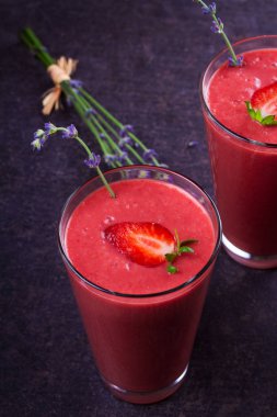 Berry smoothie çilek ve koyu ahşap arka plan lavanta çiçekleri ile süslenmiş