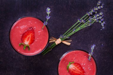 Berry smoothie çilek ve koyu ahşap arka plan lavanta çiçekleri ile süslenmiş