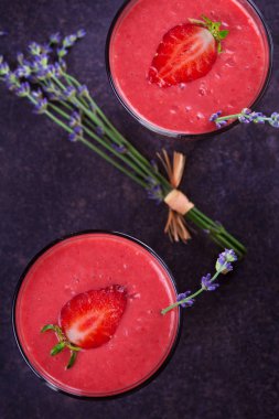 Berry smoothie çilek ve koyu ahşap arka plan lavanta çiçekleri ile süslenmiş