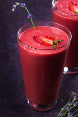 Berry smoothie çilek ve koyu ahşap arka plan lavanta çiçekleri ile süslenmiş